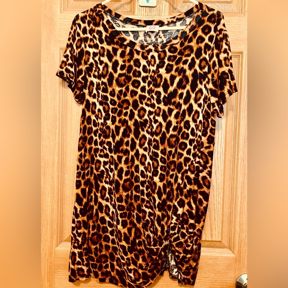 ITS A “WANNA B” SOFT KNIT TOP WITH TIE KNOT at bottom left of shirt.